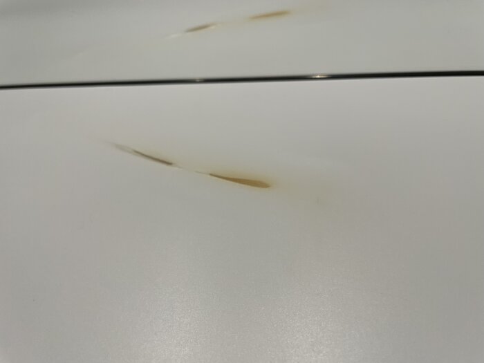 Vit yta med rostfläckar pepparrepeterade längs ytan.