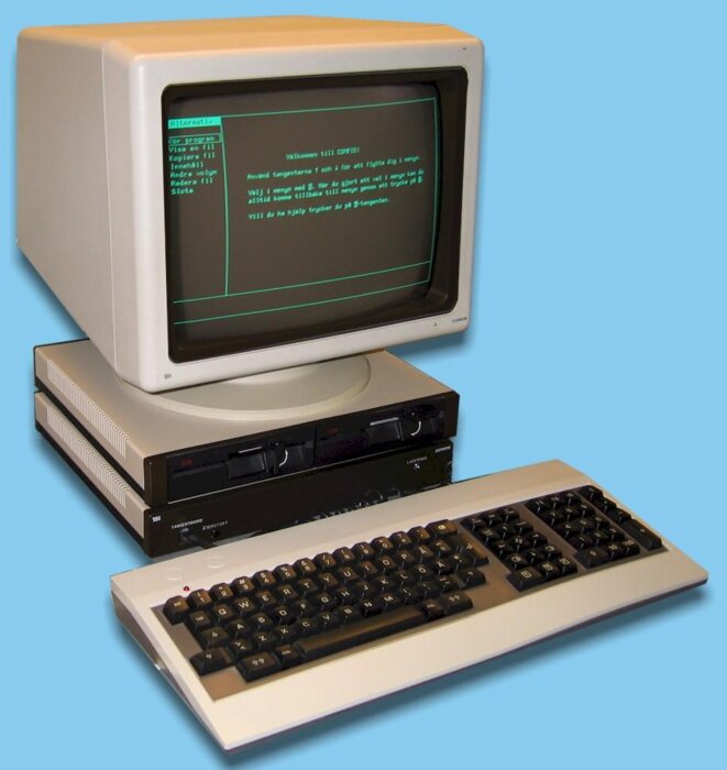 Gammal dator av märket Compis med skärm, tangentbord och diskettstationer.