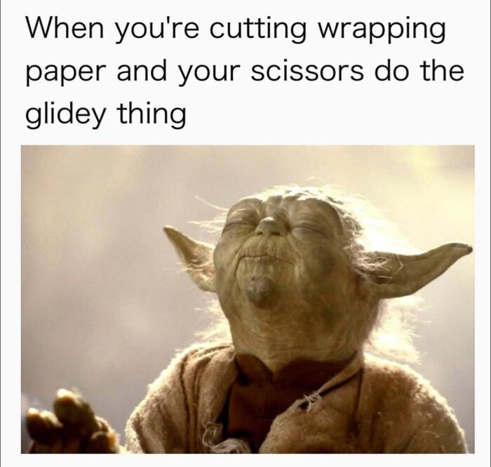 En grön, öronförsedd varelse ser nöjd ut med texten "When you're cutting wrapping paper and your scissors do the glidey thing" ovanför.