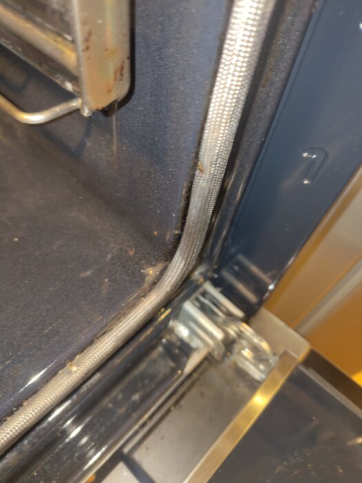 Skadad emalj i Bosch inbyggnadsugn, med synliga hål vid framkanten, avslöjar metall under. Problem med städskador diskuteras i forumet.