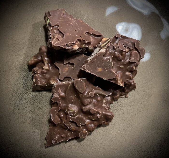 Chokladbräck med pistagenötter och valnötter på en tallrik.