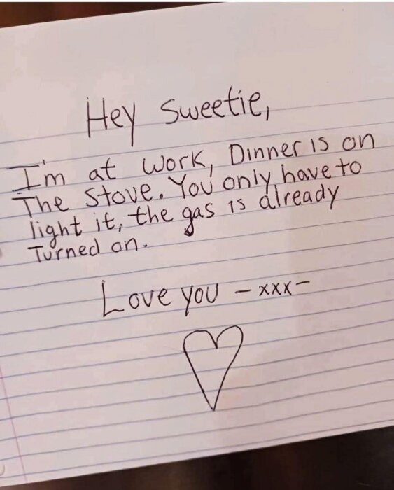 Kärleksfullt meddelande på papper som påminner någon om mat på spisen, att bara tända, gasen är på. Avslutas med "Love you" och ett hjärta.