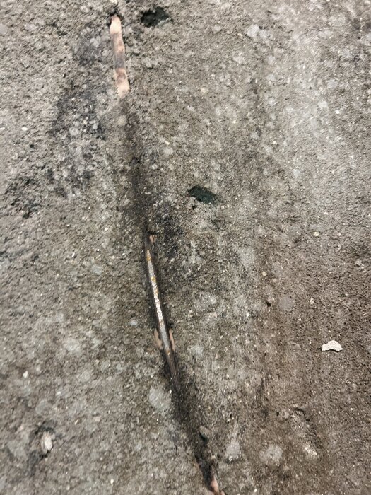 Skadat vattenrör i betonggolv, exponerat efter sanering i badrum.
