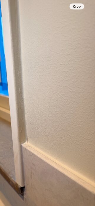 Vägg med färgskav, synliga penseldrag och ojämn färg på lister vid ett nybyggt hus.
