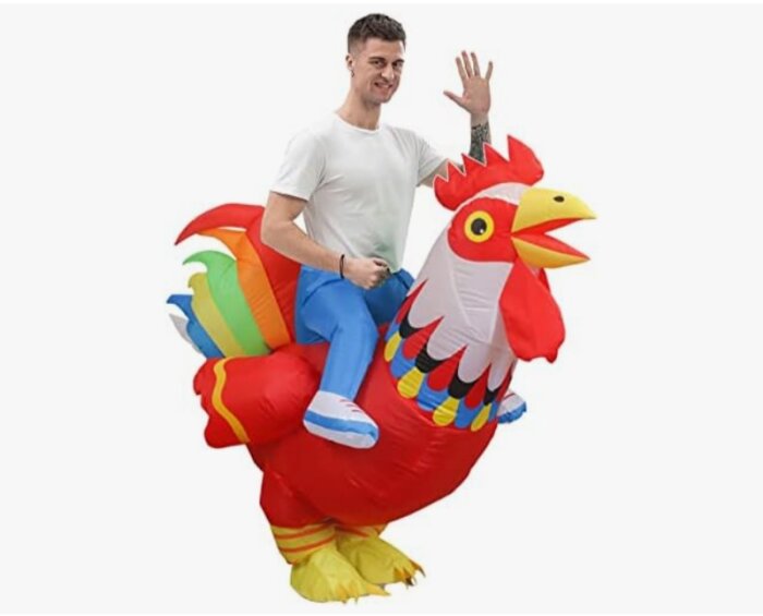 A person in a white shirt appears to be riding a colorful inflatable rooster, waving cheerfully.