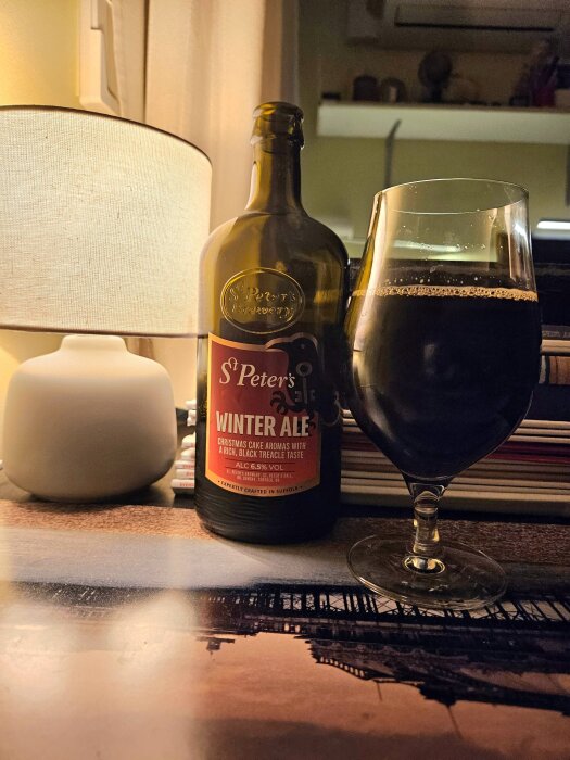 Flaska och glas med St Peter's Winter Ale, en kraftfull öl med julkakearomer och rik kolasmak.