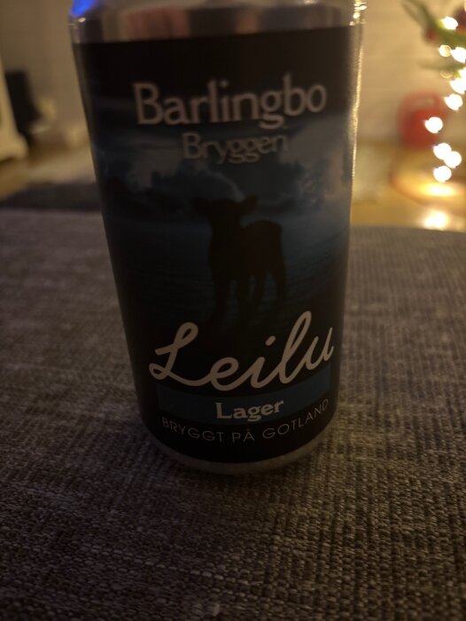 En burk öl från Barlingbo Bryggeri, märkt "Leilu Lager", stående på ett tygunderlag med suddig bakgrund.