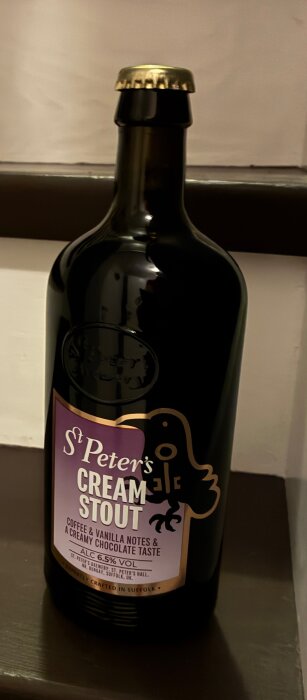 Flaska med St Peter's Cream Stout, etikett beskriver smak av kaffe och vanilj med krämig chokladsmak, 6.5% alkoholhalt.