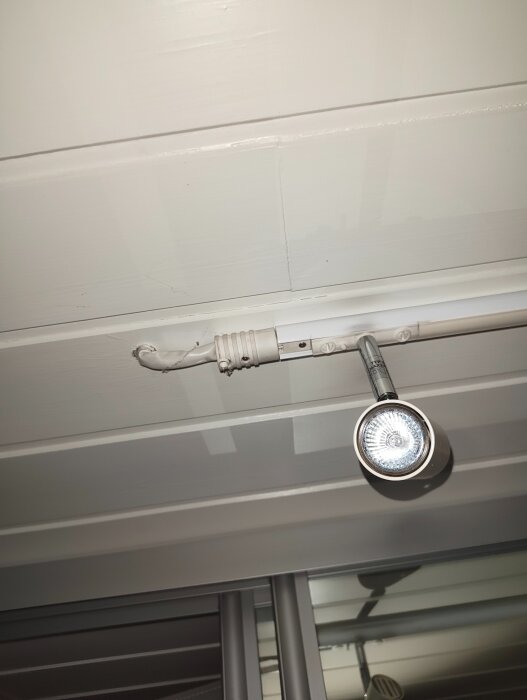Spotlight-skena monterad i taket med silverfärgad spotlightlampa.