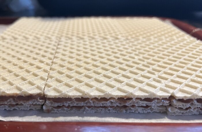 Närbild av smörgåsrån med lager av jordnötssmör och choklad, redo att delas och doppas i choklad enligt beskrivning i inlägg.