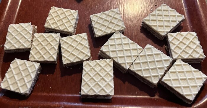Hemgjorda kexchokladrutor med jordnötssmör på en bricka, redo för chokladdoppning inför julen.
