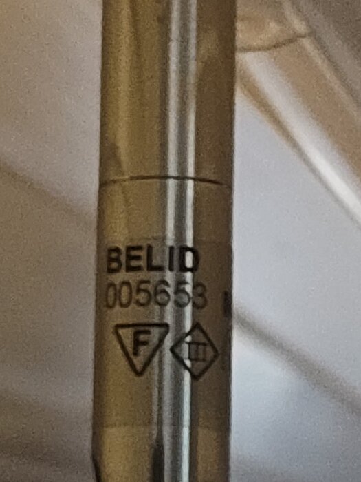 Lampa märkt "BELID 005653" med symboler för säkerhetsklass och information "Typ S 6012 Max 20W/12V".