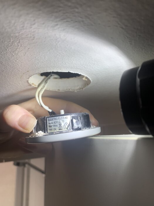 Hål i tak med uttagen dimbar spotlight och märkning på lampa visas.