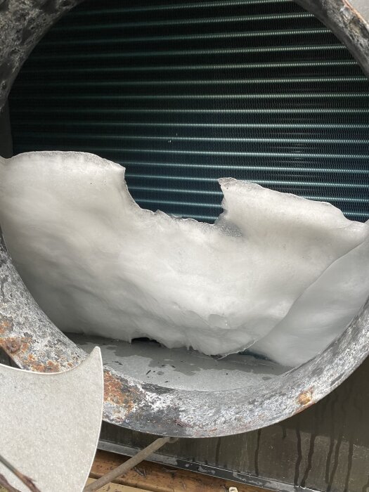Frost och isbildning i en värmepump från Thermia Atria 2010, med synliga metallkomponenter och fläktblad.