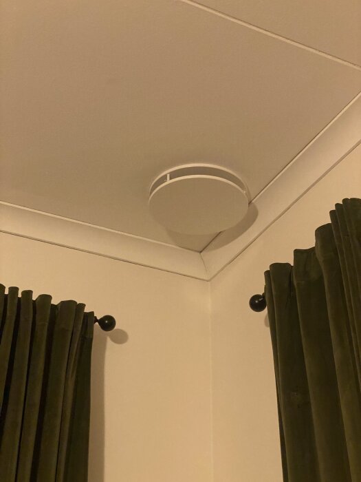 Tak med Swegon CDR ventilation, gröna gardiner vid väggen.