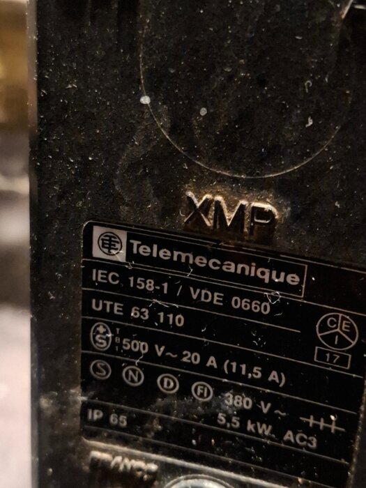 Närbild av en tryckvakt från Telemecanique med tekniska specifikationer som IEC-standard, volt och ampere information, märkt XMP.
