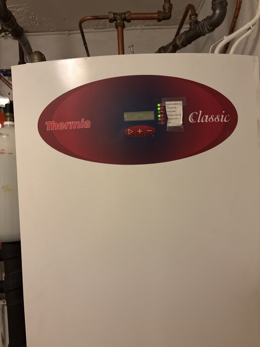 En värmepump av märket Thermia Classic med röranslutningar och en display, del av ett inlägg om problem med tryck och ljud.