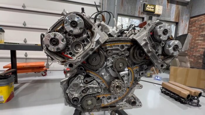 Bild av en V10-motor med synliga drev och remmar i en verkstadsmiljö, relaterad till en Lamborghini Huracan Performante.