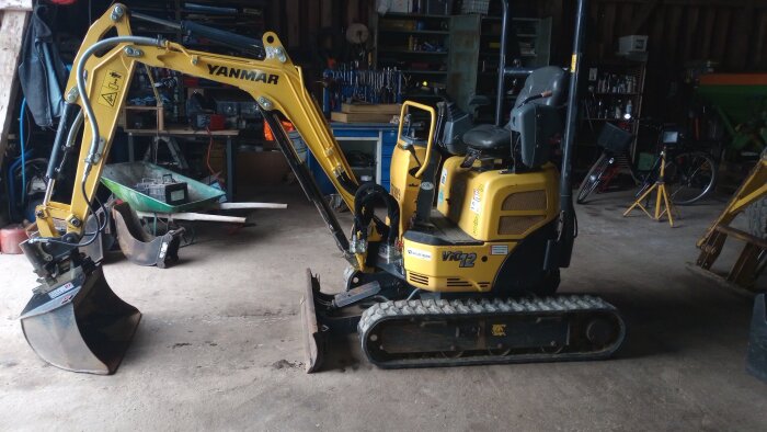Hydraulisk spade i gul färg placerad i ett garage.
