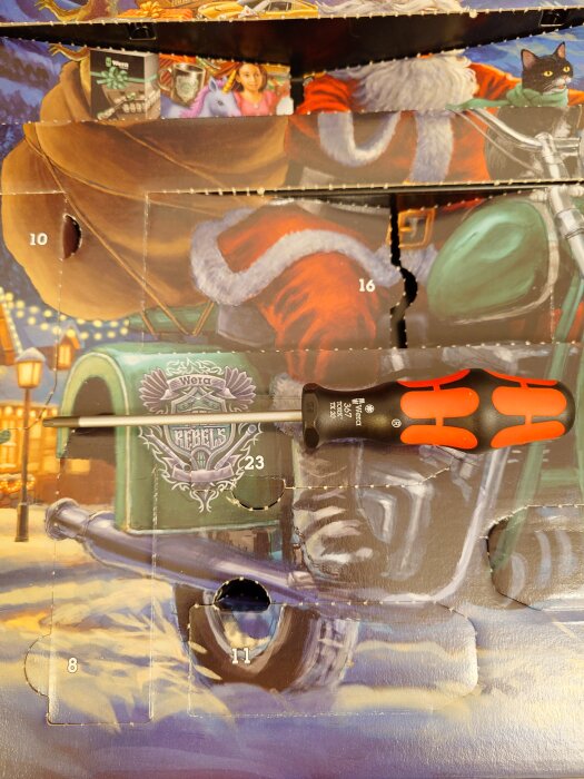 Julkalender med flera öppnade luckor och en Wera skruvmejsel placerad ovanpå. Bakgrundsbild föreställer en motorcykel.