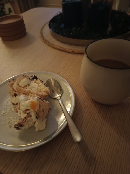 En Budapeststubbe serverad på en tallrik med en sked och en kopp kaffe på ett träbord, redo att avnjutas.