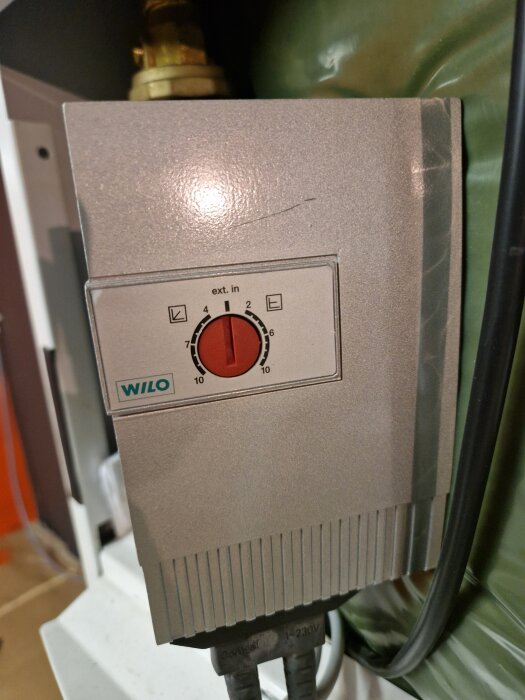 Wilo-pumpregulator med rött vred, inställd på läge 4. Kabelanslutningar syns nedtill.