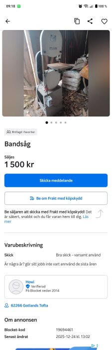 Bandsåg i garage eller förråd, omgiven av säckar och löv på golvet.