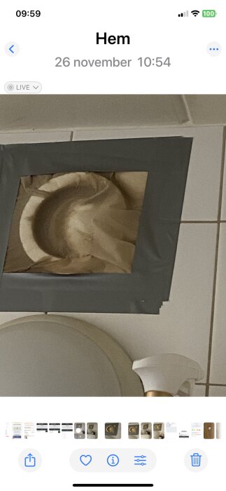 Badrumsventil med silvertejp runt kanten på en kaklad vägg, misstänkt plats för insektproblem.
