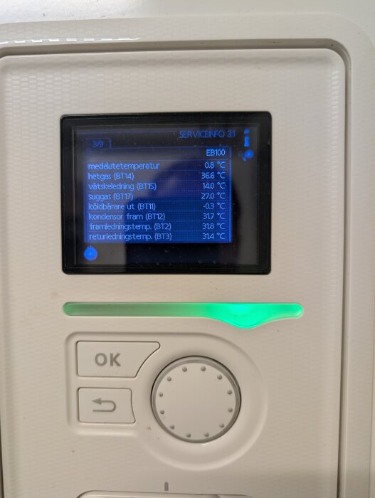 Display som visar temperaturvärden för ett värmesystem med knappar och reglage på en enhet.