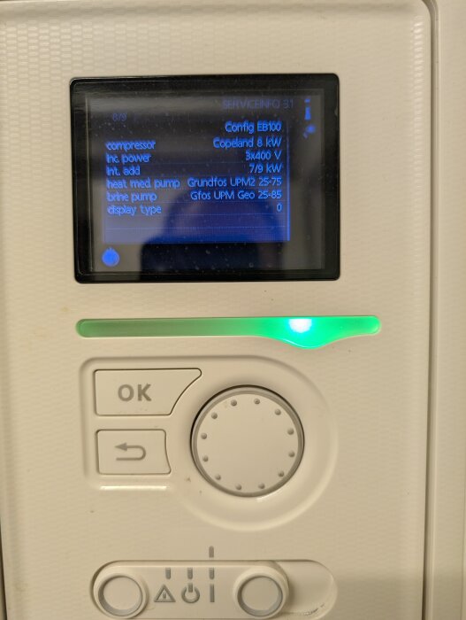 Display på värmepumpskontrollpanel med serviceinformation om kompressor, effekt, värmepump och brine pump.
