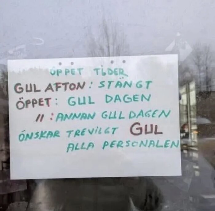 Skylt med öppettider för "Gul afton", "Gul dagen" och "Annan gul dagen", samt önskan om trevlig gul från personalen, placerad på fönster.