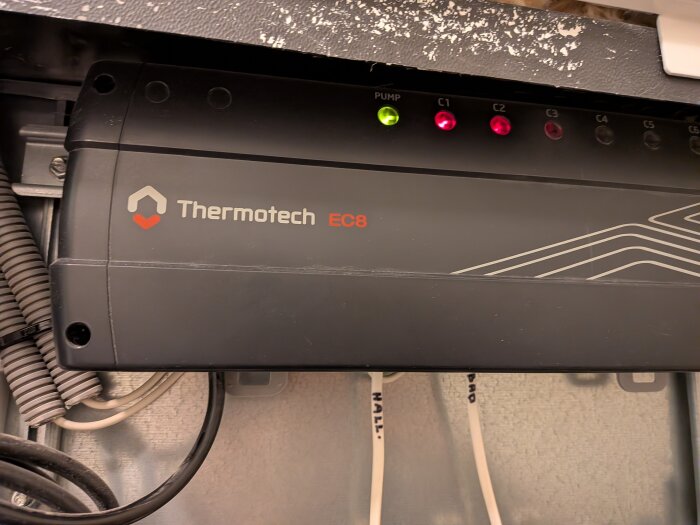Termotech EC8 styrenhet för golvvärme med lysande indikatorlampor, i en värmeinstallationsmiljö.