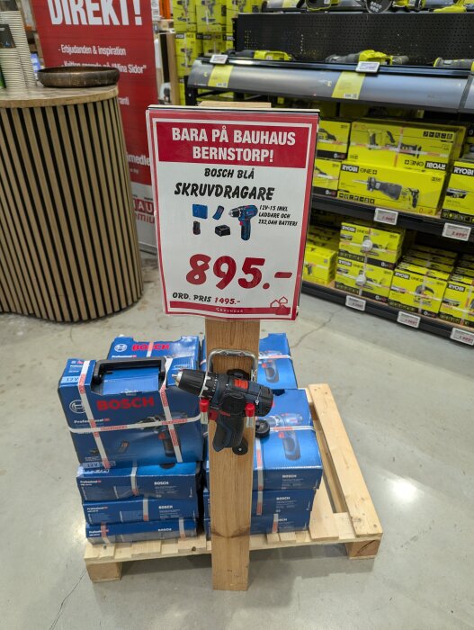 Bauhaus-erbjudande på Bosch GSR 12V-15 skruvdragare, pris 895 kr. Produkten visas på en träpall framför hyllor i butiken.