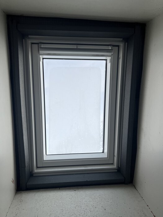 Nytt takfönster med mindre glasarea än tidigare, omringat av isolering och takmaterial.