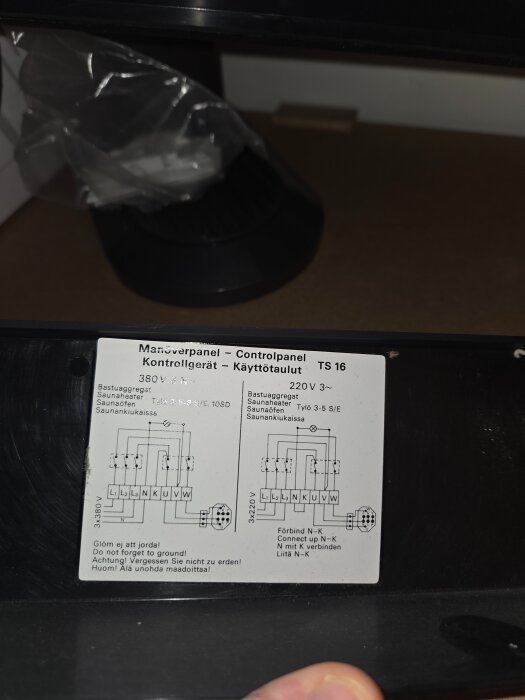 Etikett med kopplingsschema för en kontrollpanel, modell TS 16, med instruktioner för 380 V och 220 V bastuaggregat.