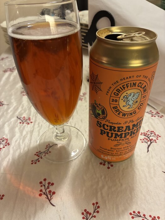Pumpkin-ale från Griffin Claw på ett bord med rödvit duk, bredvid ett glas med samma ölsort.