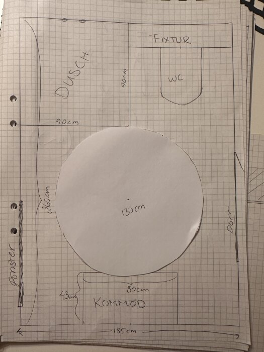 Ritning av badrum på rutat papper, visar dusch, WC, kommod och dörrar, med måttangivelser och en cirkel markerad 130 cm.