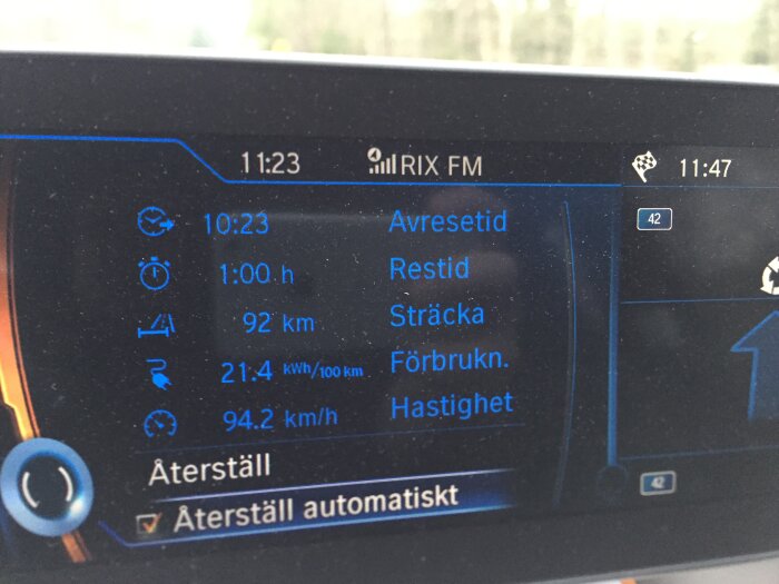 BMW I3 skärm med data: avresetid 10:23, restid 1 timme, sträcka 92 km, förbrukning 21,4 kWh/100 km, hastighet 94,2 km/h.