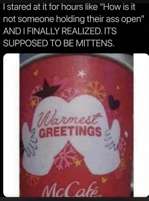 Text på en McCafé-kopp med två vantar, hjärtan och snöflingor. Texten lyder "Warmest Greetings" i mitten.