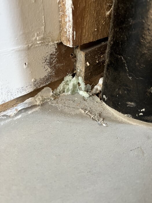 Flytspacklat golv med upphöjt glasfibernät vid väggen, trästruktur synlig och rester av markörer kvar.