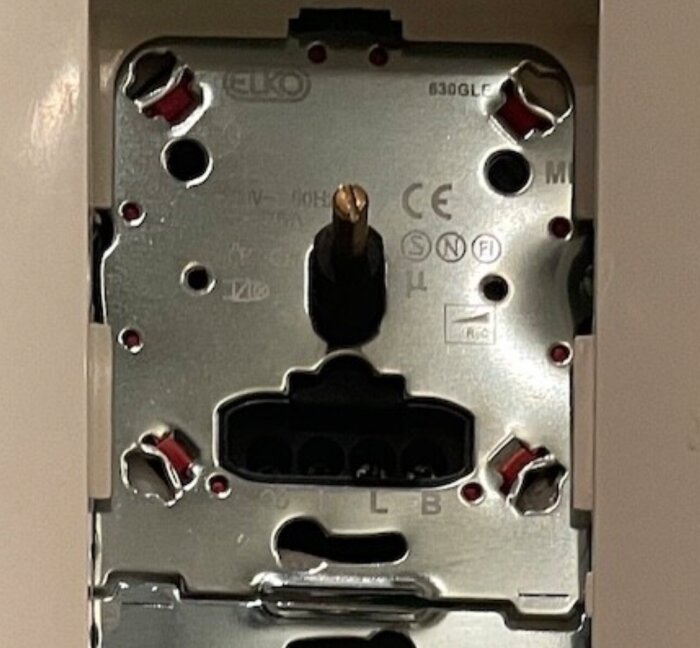 Baksidan av en ELKO 630GLE dimmer med metallkretsar och anslutningsportar, använd i ett hem för att kontrollera halogenlampor.