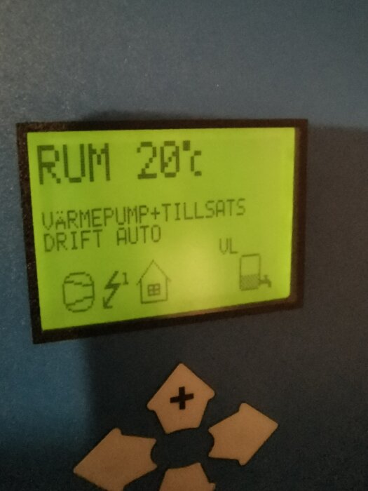 Display på värmepump visar rumstemperatur 20°C och status "Värmepump+Tillsats Drift Auto" med symboler.