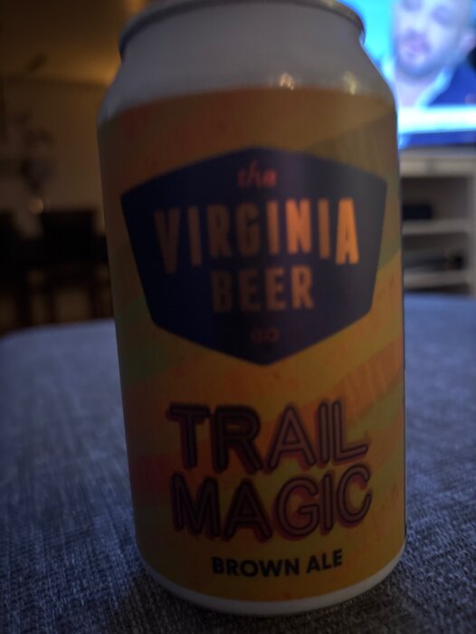 Burk med The Virginia Beer Co. Trail Magic Brown Ale i ett vardagsrum.
