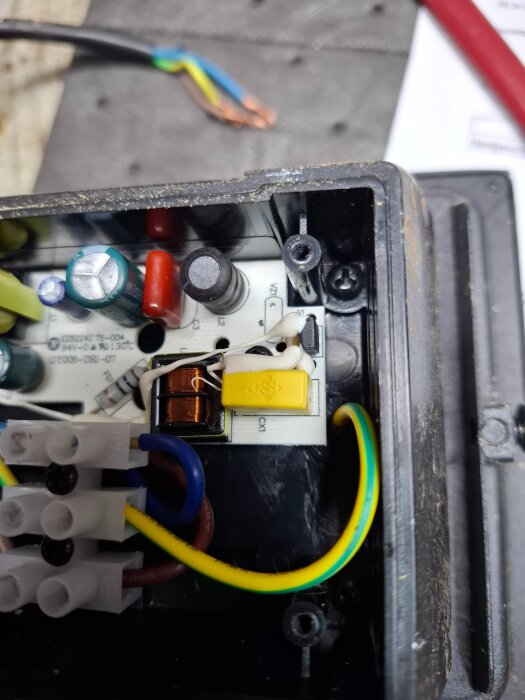 Närbild av en Biltemaarmaturs öppnade elektriska komponenter med synliga kopplingar och ledningar.