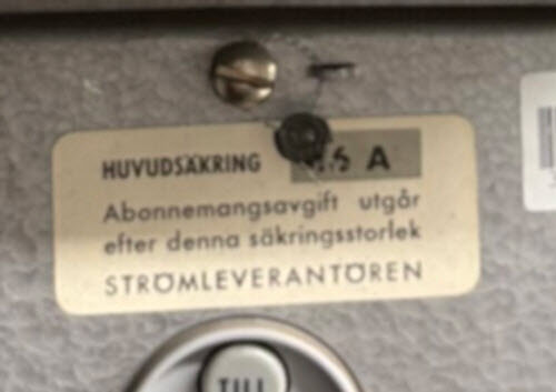 Skylt på mätartavla med text om huvud­säkring och abonnemangs­avgift, säkrings­storlek 3x16 A.