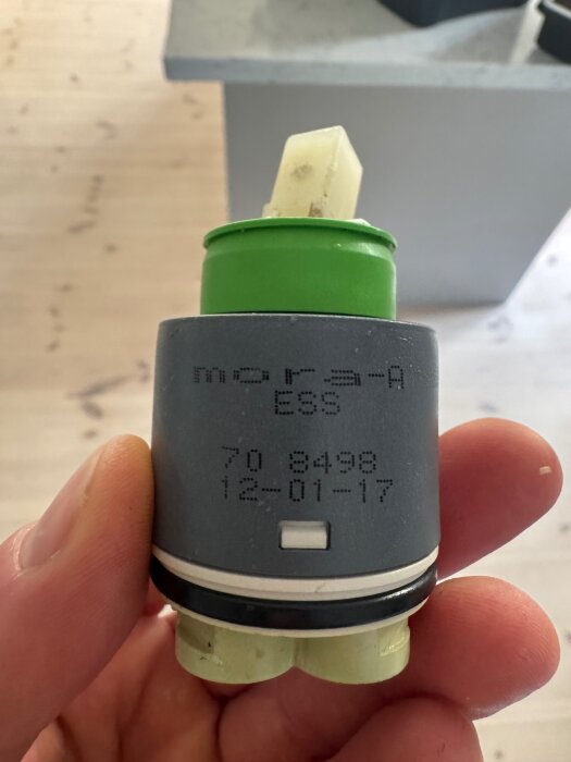 En keramisk insats med texten "MORA ESS 70 8498 12-01-17" hållen i en hand.