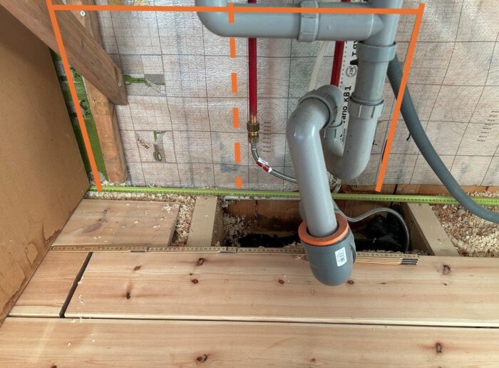 Tillfällig installation av vatten- och avloppsrör under ett pågående köksbygge, med synliga rör och kapsyl nere vid golvet.