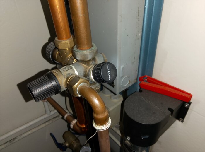 Vred på varmvattenberedare för avstängning, kopparrör och ventil synliga.
