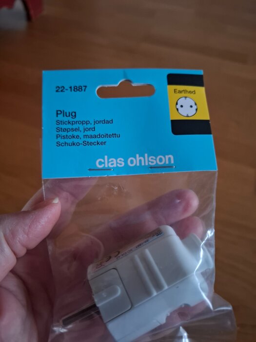 Förpackning innehållande en jordad stickpropp från Clas Ohlson, modell 22-1887.