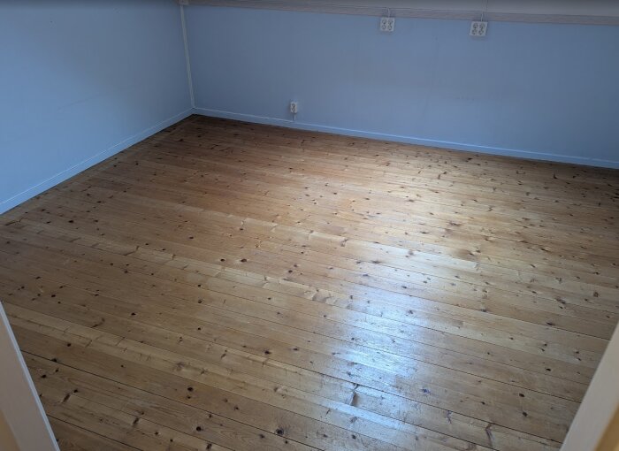 Nyslipat och behandlat trägolv med Osmo Hårdvaxolja i rum på tredje våningen, redo för kontorsanvändning.